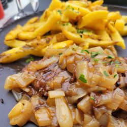 Beef with sautéed scallions and a side of fries