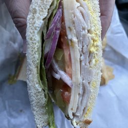 Dinty's Market & Deli - Turkey on white bread with pepper Jack cheese, lettuce, onions, tomatoes, and pickles.