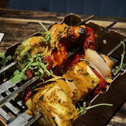 Sura Indian Bistro - Kebab Trio: Smoked Trio of Paneer, Chicken, and Shrimp Kebabs with Pickled Peppers, Onions, and smothered in Cashew Sauce.