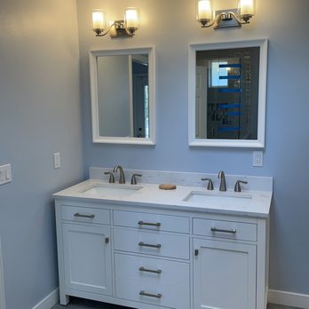 Pacific View Builders - a bathroom with two sinks and two mirrors - General Contractors Near Me