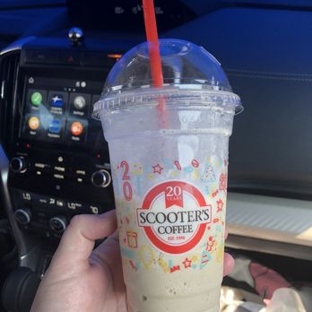 Scooter's Coffee - a hand holding a cup of coffee - Coffee & Tea Near Me - The Colony, Texas Scooter's Coffee - a hand holding a cup of coffee - Coffee & Tea Near Me - The Colony, Texas