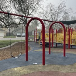 Kloss Park - Toddler and regular swing. Big kid structure in background