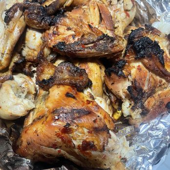 El Pollo Cris Cris - Chicken - Grilled chicken pieces with charred skin and seasoning, placed on aluminum foil, showing a mix of cooked and slightly burnt areas. - Mexican Near Me - Chicago, Illinois