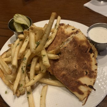 Addison's - Louie's flatbread cuban - A meal featuring a grilled quesadilla, French fries with herbs, sliced pickles, and two dipping sauces on a white plate at a restaurant. - New American Near Me - Columbia, Missouri