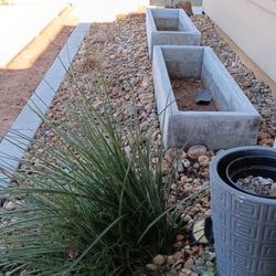 Cutters Lawn and Landscape - Custom planter boxes surrounded by Wisconsin Cobblestone. One Brake Light yucca and moss covered boulders on the far end.