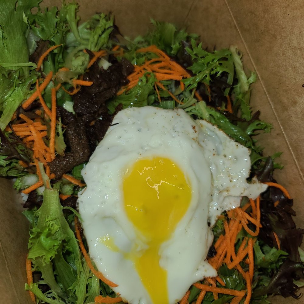a fried egg on top of a salad a fried egg on top of a salad