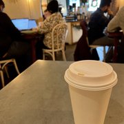 Photo of Brothers & Sisters Co Coffeehouse + Cafe - Brookline, MA, United States. Medium hot chai with almond milk in a cozy setting / Dec. 2022
