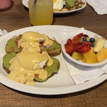 Stacked Pancake - Avocado toast with poached eggs and hollandaise sauce. And fresh fruit - Breakfast & Brunch Near Me - Waterdown, Ontario