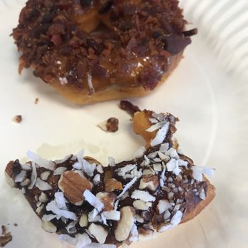 Desert Donuts - Half eaten Almond Joy doughnut and a whole Maple Bacon. - Donuts Near Me - Phoenix, Arizona Desert Donuts - Half eaten Almond Joy doughnut and a whole Maple Bacon. - Donuts Near Me - Phoenix, Arizona