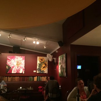 Cafe This Way - Highly styled dining  room with art, books, candles, and varied seating groups. - New American Near Me - Bar Harbor, Maine