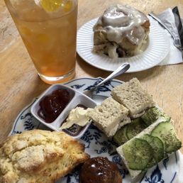 Afternoon Tea Set featuring chicken salad sandwich, cucumber sandwich, honey vanilla scone, tea cake, and Chai tea. Bonus cinnamon roll.