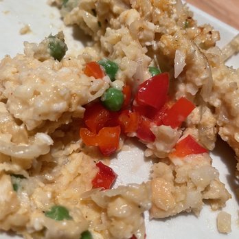 Red's Place - A close-up of scrambled eggs mixed with green peas, diced red bell peppers, and chopped vegetables on a white plate. The dish appears freshly cooked with visible ingredients and a slightly creamy texture. - New American Near Me - Ithaca, New York
