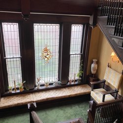 Culbertson Mansion - The gorgeous leaded stained glass window of the grand staircase with a cozy window seat.