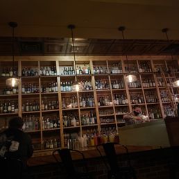 a bar with shelves full of bottles a bar with shelves full of bottles