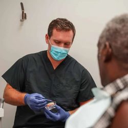 Smart Arches Dental Implants - Smart Arches clinician explaining the process of dental implants to a patient.
