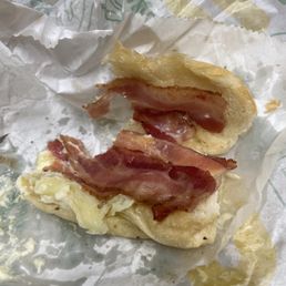 a half eaten bacon and egg sandwich a half eaten bacon and egg sandwich