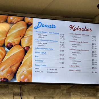 Nom Donuts - Menu - Digital menu board listing prices for various donuts and kolaches, including flavors and options, at a bakery or donut shop. - Donuts Near Me - Houston, Texas