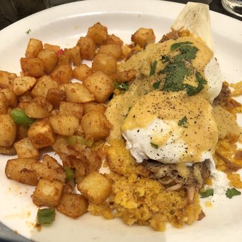 Hash Kitchen - Tamale Corn Cake eggs Benedict with green chili pork and hollandaise. Side of potatoes with green and red pepper. - Breakfast & Brunch Near Me - Peoria, Arizona
