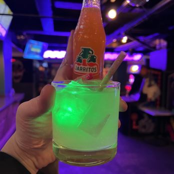 Quarters Arcade Bar - a person holding a glass with a drink in it - Arcades Near Me - Salt Lake City, Utah Quarters Arcade Bar - a person holding a glass with a drink in it - Arcades Near Me - Salt Lake City, Utah