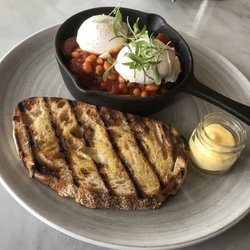 French Village - Chorizo and chipotle baked beans with poached eggs and sourdough