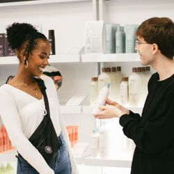 Aveda Institute & Academy Salon - Guest being shown products in our EC