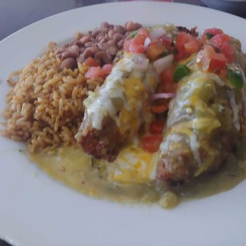 The Original Blue Adobe Grille - Spooning Rellenos with green chili. - Mexican Near Me - Mesa, Arizona The Original Blue Adobe Grille - Spooning Rellenos with green chili. - Mexican Near Me - Mesa, Arizona