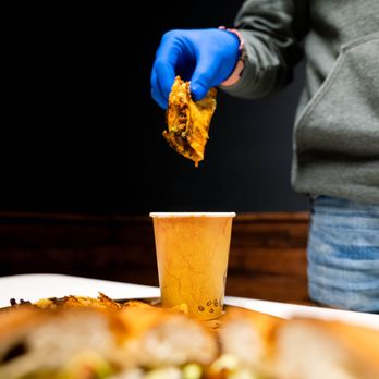Tacos El Jerry - a person in blue gloves holding a piece of food - Food Trucks Near Me - Watsonville, California