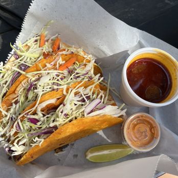 CJ's Tacos - a hand holding a hot dog - Food Trucks Near Me - Austin, Texas