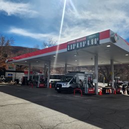 a gas station with cars parked in front