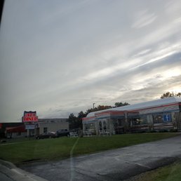 Coming into to restaurant - Exterior of 371 Diner with a lit sign, parking lot, and a building with a Facebook logo, under a cloudy sky.