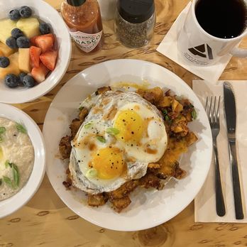 AlMack's Kitchen - Cajun Hash (potatoes, bacon, green onion, cheddar, eggs to-order), substituted fruit instead of toast. I added a side of grits with butter. - Sandwiches Near Me - Trinidad, Colorado