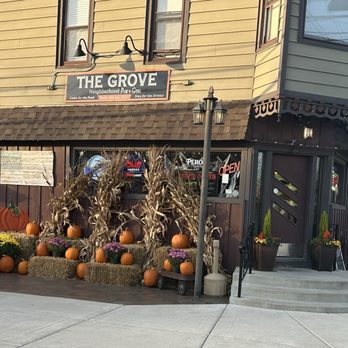 The Grove Pub & Grill - Front door and side display of Fall decor. The outside patio is to the left of pumpkins. - Pubs Near Me - Spring Grove, Illinois