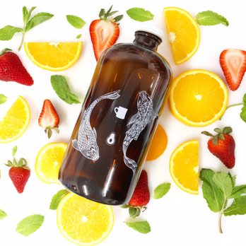 Orange Avocado Juicery - a bottle of juice surrounded by oranges and strawberries - Juice Bars & Smoothies Near Me - Boardman, Ohio