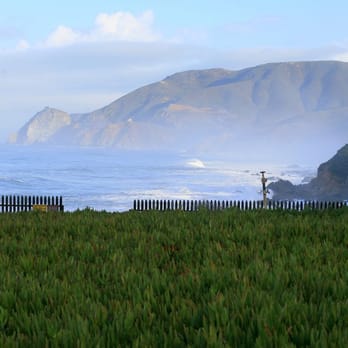 HI Point Montara Lighthouse Hostel - Green fields, danger signs, distant mountains, and raging surf - Hostels Near Me - Montara, California
