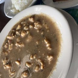 Stewed conch, grits, and Johnny cake