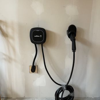 Infinity EV Infrastructure Consultants. - Wallbox 40A installed in a garage with plug in option into a NEMA 14-50 outlet. - Electricians Near Me