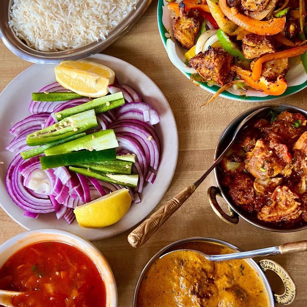 Naan Pizza - various dishes of food on a table - Indian Near Me - Muskegon, Michigan Naan Pizza - various dishes of food on a table - Indian Near Me - Muskegon, Michigan