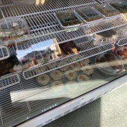 M&E Syrian Cuisine - Prepared food items on a glass enclosed refrigerated display shelves.