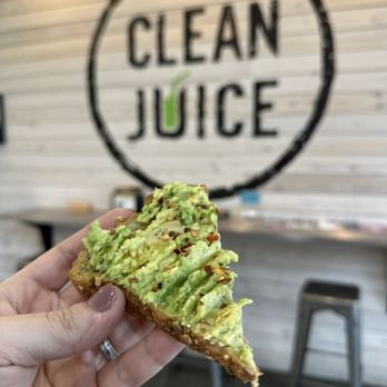 Clean Juice - a hand holding a piece of bread with avocado on it - Juice Bars & Smoothies Near Me - Greensboro, North Carolina Clean Juice - a hand holding a piece of bread with avocado on it - Juice Bars & Smoothies Near Me - Greensboro, North Carolina