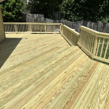 Hollodon Construction - a wooden deck with railings - General Contractors Near Me