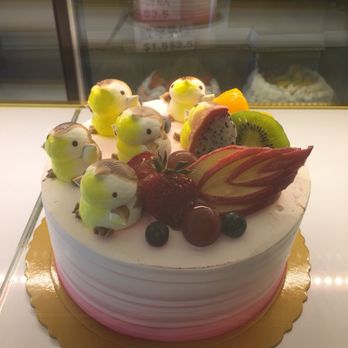 Sheng Mary Bakery - Vanilla layered sponge cake with taro filling, topped with cream penguins, fruit, and an apple cut into a swan. - Bakeries Near Me - Flushing, New York Sheng Mary Bakery - Vanilla layered sponge cake with taro filling, topped with cream penguins, fruit, and an apple cut into a swan. - Bakeries Near Me - Flushing, New York