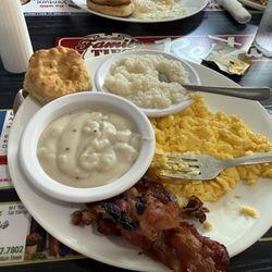 Sausage and gravy biscuit, grits, scrambled eggs and bacon.