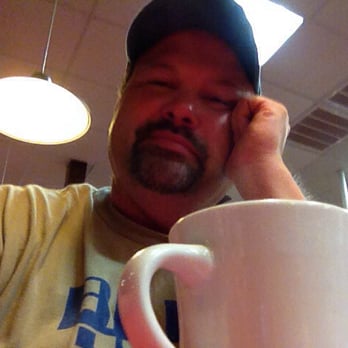 Huddle House - a man holding a coffee mug - Diners Near Me - Cheraw, South Carolina