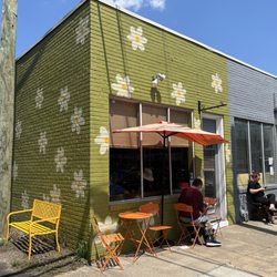 Two tables and a bench outside, 4 small window counter stool seats inside.
