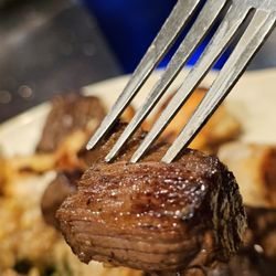 Kabuki Japanese Steak House & Sushi Bar - A juicy piece of medium rare Filet Mignon on a fork.