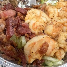 Loaded baked potato with three meats ! Grilled shrimp bacon and carne asada .