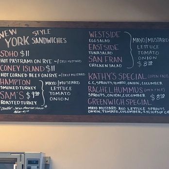 Levy's Bagels - Menu - The chalkboard menu features New York-style sandwiches such as Soho, Coney Island, Hampton, and Sam's, with prices ranging from $9.90 to $11. It lists ingredients like hot pastrami, corned beef, smoked turkey, and roasted turkey, with options for deli mustard, mayonnaise, lettuce, tomato, and onion. The menu also details daily specials including Westside, Eastside, San Fran, Kathy's, Rachel Hummus, and Greenwich Special, with ingredients and prices. The board is framed and mounted on a wall, with a small note about cheese and turkey options at the bottom. - Bagels Near Me - Alameda, California