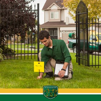 Weed Man - a man kneeling in front of a fence holding a sign - Lawn Services Near Me - Winchester, Virginia Weed Man - a man kneeling in front of a fence holding a sign - Lawn Services Near Me - Winchester, Virginia
