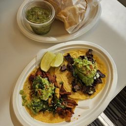 Guac and chips on top; tacos on bottom, al pastor on the left and carne asada on the right Guac and chips on top; tacos on bottom, al pastor on the left and carne asada on the right
