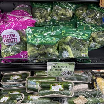 Trader Joe's - Organic broccoli florets and stalks are arranged on shelves in a grocery store, with packaging and price labels visible. - Grocery Near Me - Brooklyn, New York